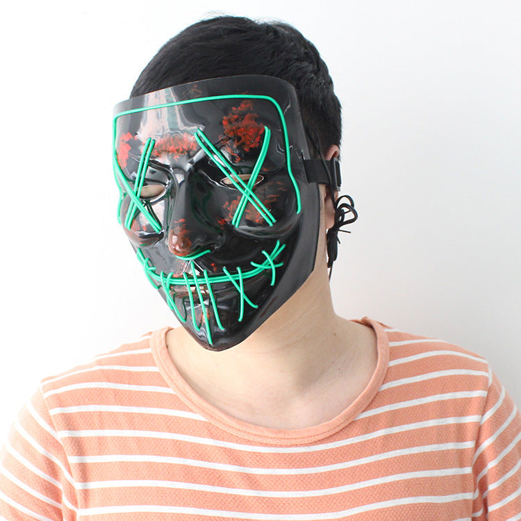 Person wearing a black LED mask with green lights.